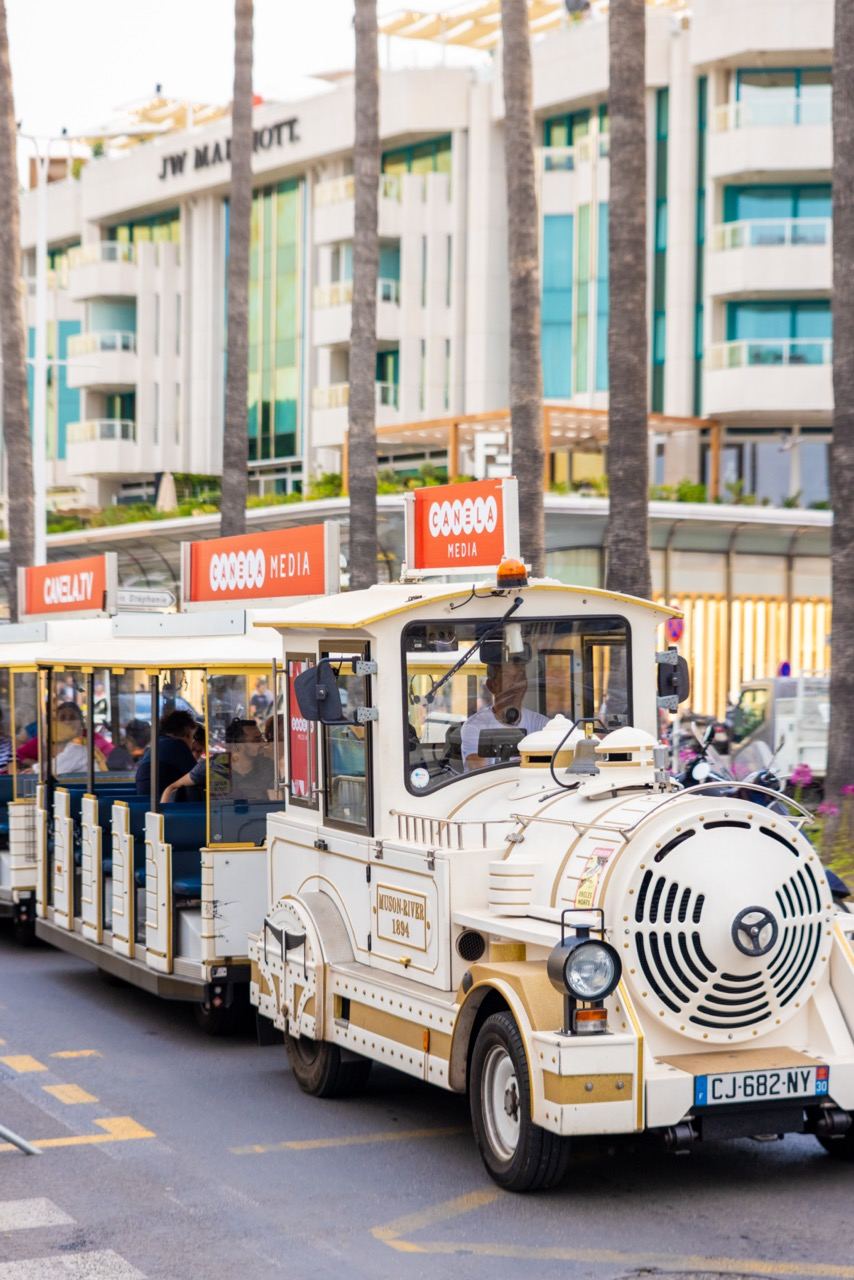 Panneaux publicitaires de toit sur le Petit Train de Cannes, devant le JW Marriott sur la Croisette